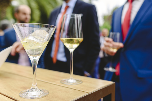 People in a cocktail drinking alcohol from their glasses and having fun at the party.