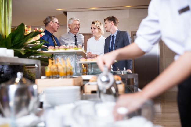 four-smiling-business-people-buffet-table_1262-1832